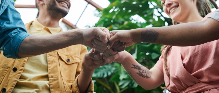 Image of people fist bumping.