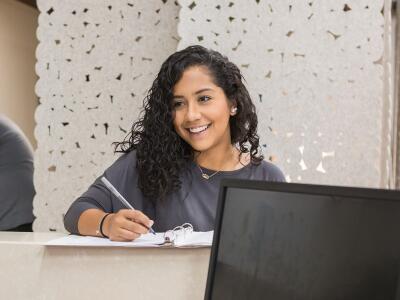 woman signing in at front desk