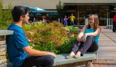 man and woman sitting outside in HopeWay courtyard
