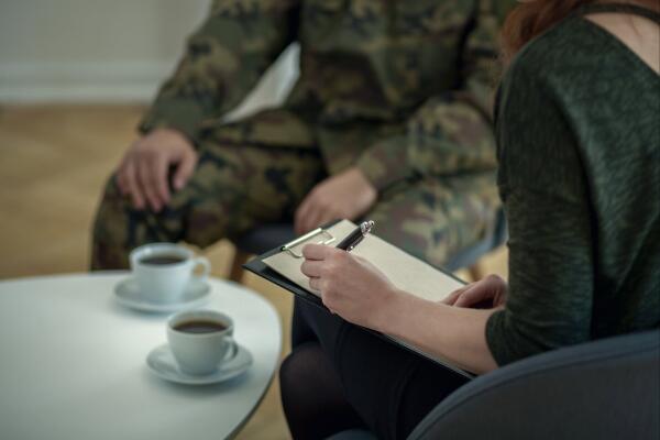 therapist writing notes in session with Veteran